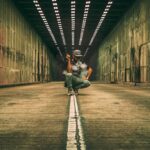 man smoking a vape sitting inside a tunnel